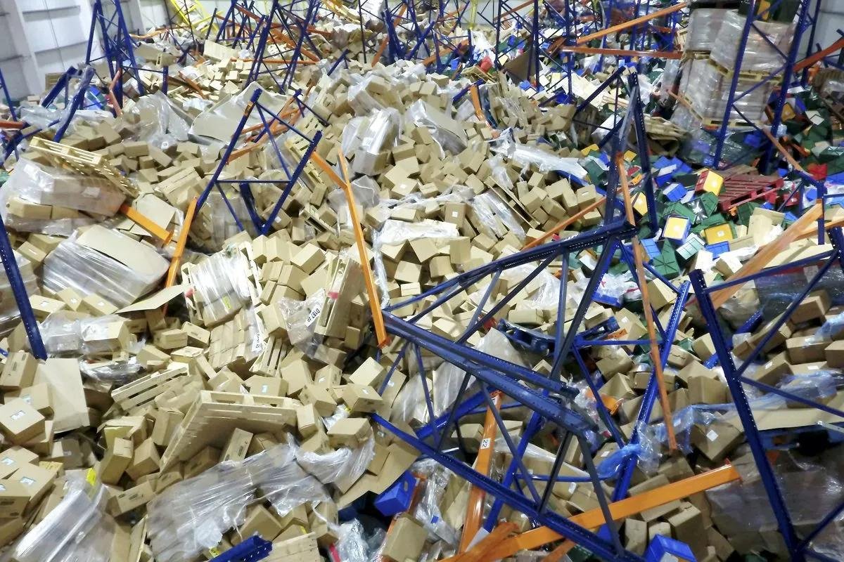 Racks colapsados y mercadería esparcida en el piso de un almacén