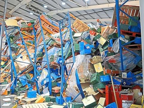 Estanterías de almacén colapsadas con cajas caídas